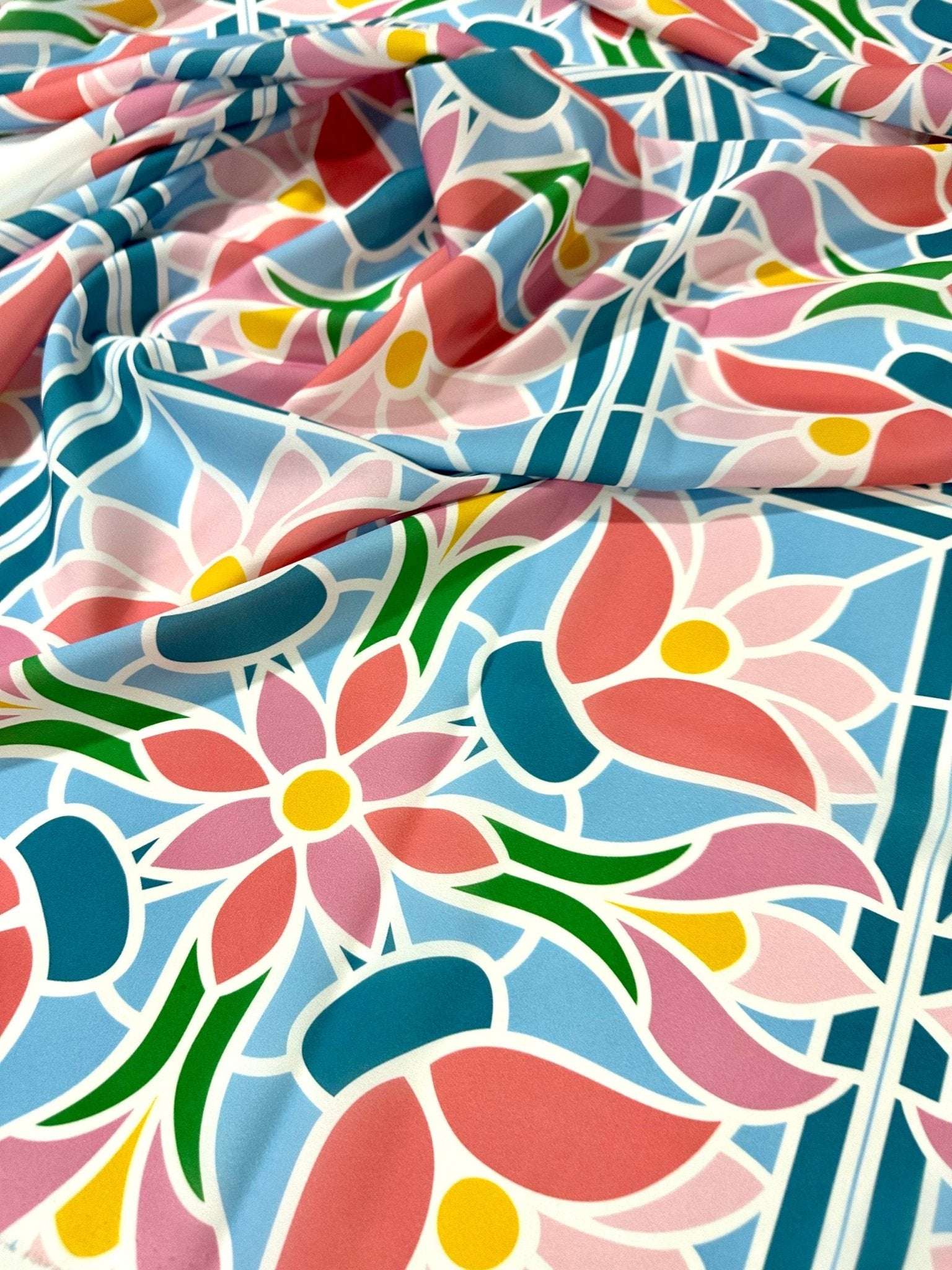 Colorful mosaic floral fabric with pink, blue, green, and yellow pattern, perfect for sewing and quilting projects