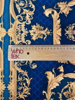 Vintage peacock pattern fabric with intricate gold designs on a deep blue background and a ruler for scale